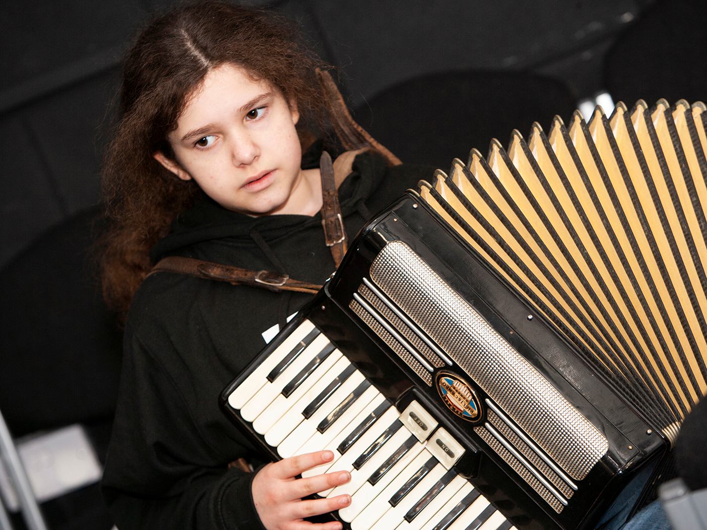 Young woman with accordion in workshop