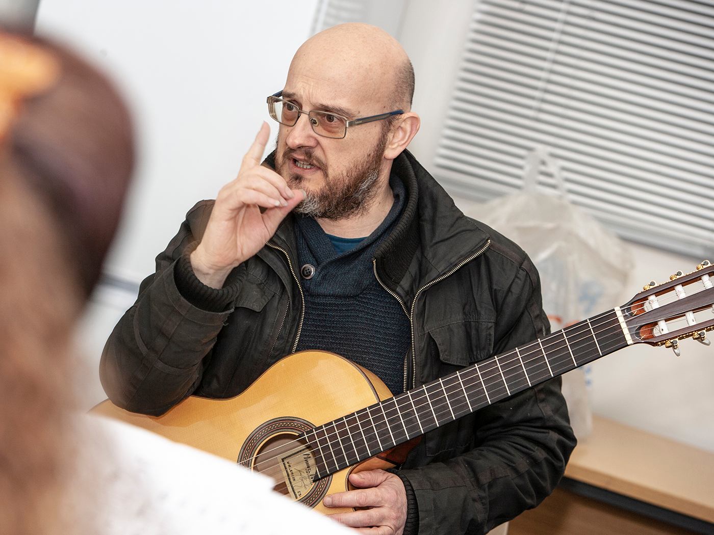 Guitar tutor making a point in workshop