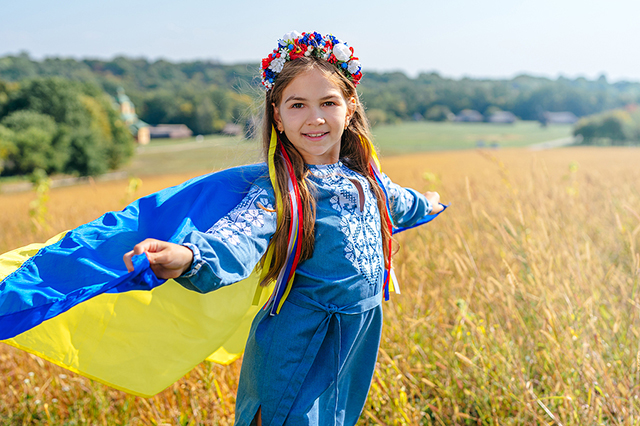 Ukrainian girl in field with flag of Ukraine